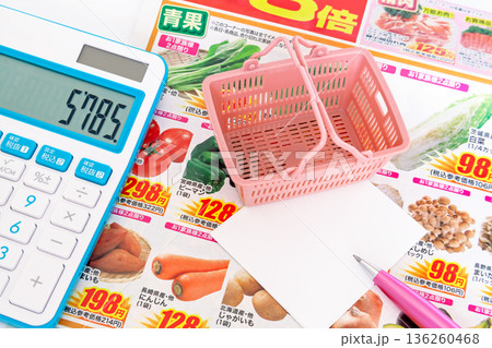 新聞折り込みチラシを見ながら特売品をメモするイメージ 新聞折り込みチラシを見ながら特売品をメモするイメージ 136260468