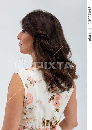 Serene female figure with floral attire and reflective mood, Graceful female profile dressed in flowers against soft studio background for versatile promotional purposes Serene female figure with floral attire and reflective mood, Graceful female profile dressed in flowers against soft studio background for versatile promotional purposes 136260924