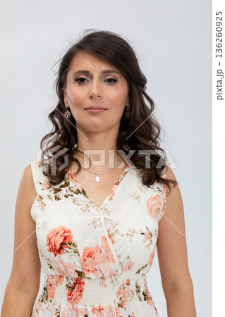 Business casual female model with polished makeup and friendly expression, Female studio portrait showcasing elegant floral attire and approachable demeanor with neutral background Business casual female model with polished makeup and friendly expression, Female studio portrait showcasing elegant floral attire and approachable demeanor with neutral background 136260925