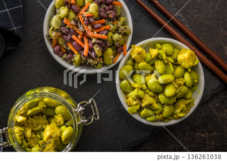 Fresh salad with edamame beans in bowl on black table. Fresh salad with edamame beans in bowl on black table. 136261038