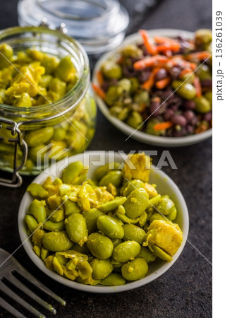 Fresh salad with edamame beans in bowl on black table. 136261039