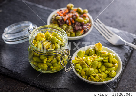 Fresh salad with edamame beans in bowl on black table. Fresh salad with edamame beans in bowl on black table. 136261040