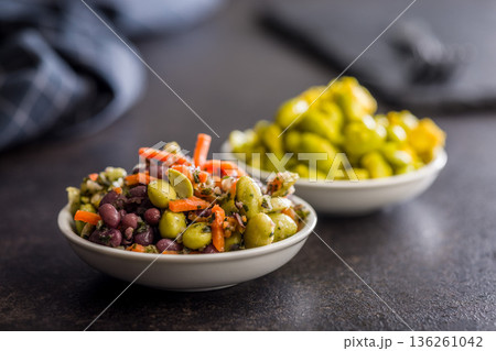 Fresh salad with edamame beans in bowl on black table. Fresh salad with edamame beans in bowl on black table. 136261042