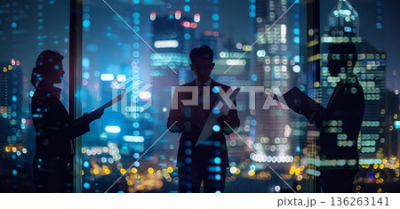 Three business people stand together holding documents in a modern office. They are surrounded by a vibrant city skyline at night with many lights Three business people stand together holding documents in a modern office. They are surrounded by a vibrant city skyline at night with many lights 136263141