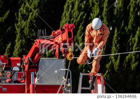 出初式の救助活動の実演で張り巡らせたロープをロープ渡りするレンジャー消防隊員 136264606