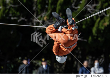 出初式の救助活動の実演で張り巡らせたロープをロープ渡りするレンジャー消防隊員 136264609