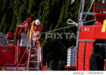 出初式の救助活動の実演で張り巡らせたロープをロープ渡りするレンジャー消防隊員 136264613