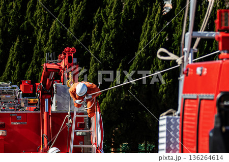 出初式の救助活動の実演で張り巡らせたロープをロープ渡りするレンジャー消防隊員 136264614