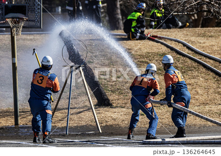 出初式で的に向けて放水訓練を実演する消防隊員 136264645