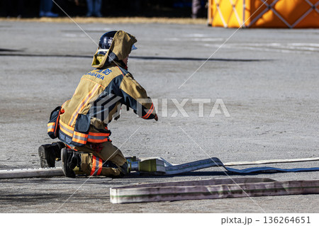 出初式で放水訓練を実演するためにホースを準備する消防隊員 136264651