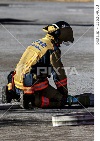 出初式で放水訓練を実演するためにホースを準備する消防隊員 136264653