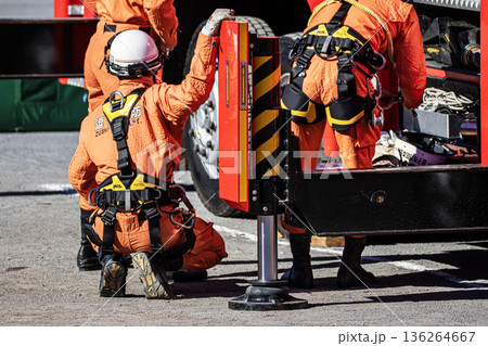 出初式で消防訓練を実演するために消防車の脇で準備をする消防隊員 136264667