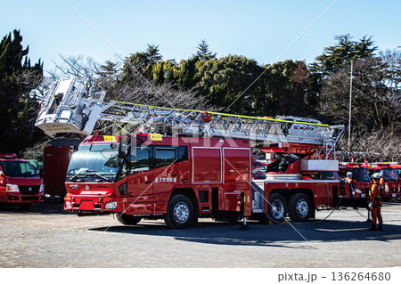 出初式ではしご付消防車のはしごを伸ばし救助活動を実演する消防隊員 136264680