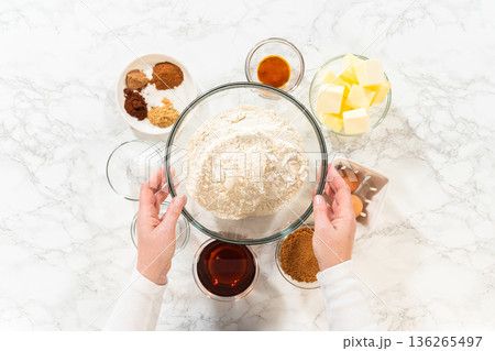 Top view of ingredients for Amber Gingerbread Cookie Dough, including flour, butter, eggs, brown sugar, molasses, and various spices, arranged on a marble surface. Top view of ingredients for Amber Gingerbread Cookie Dough, including flour, butter, eggs, brown sugar, molasses, and various spices, arranged on a marble surface. 136265497
