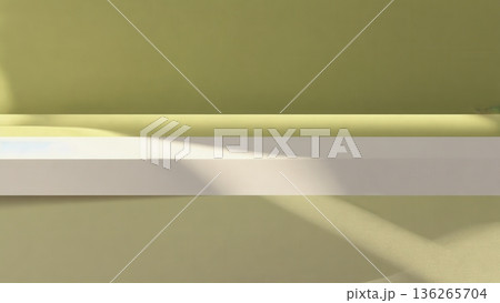 A simple horizontal shelf casts long soft shadows against a muted green wall. The composition highlights light, space, and minimal form. 136265704
