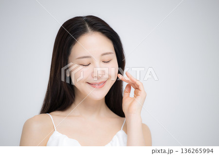 頬に手を添えて微笑む日本人女性の美肌スキンケア清潔感ポートレート　目を閉じる	 136265994