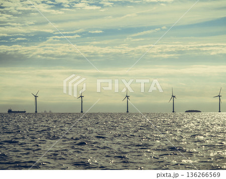 Wind turbines power generator farm along coast sea 136266569