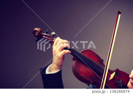 Man man dressed elegantly playing violin 136266974