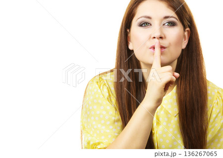 Woman asking for silence with finger on lips 136267065