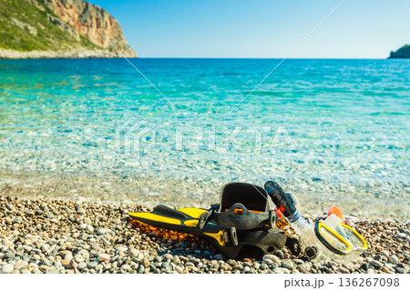 Flippers and snorkeling tube on sea shore 136267098