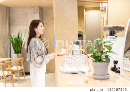 カフェのカウンター前に立つ若い女性 136267396