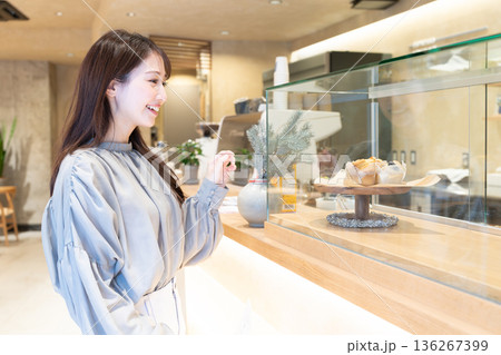 カフェのカウンター前に立つ若い女性 カフェのカウンター前に立つ若い女性 136267399