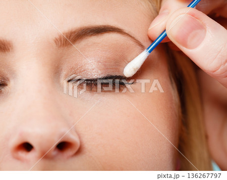 Woman getting her makeup done with cotton buds 136267797
