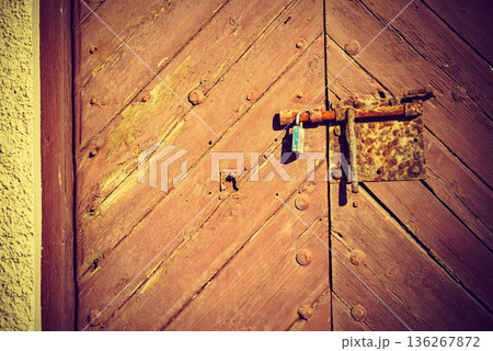 Old wooden door with rustic lock 136267872