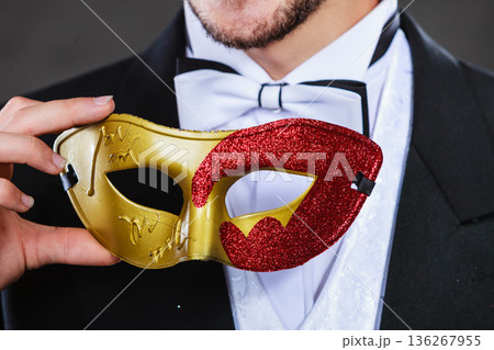 Male hand holds carnival mask closeup 136267955
