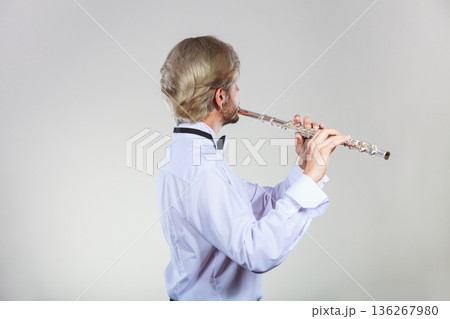 Male flutist playing his flute Male flutist playing his flute 136267980