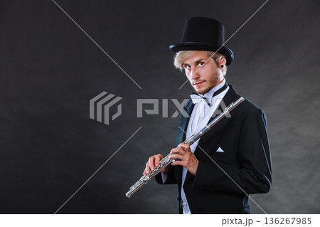 Elegantly dressed musician holding flute Elegantly dressed musician holding flute 136267985