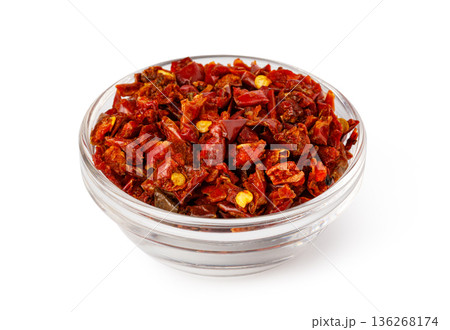 Dried red chopped chili pepper flakes in glass bowl 136268174