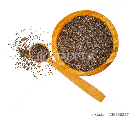 Chia seeds filling wooden bowl and spoon overhead Chia seeds filling wooden bowl and spoon overhead 136268237