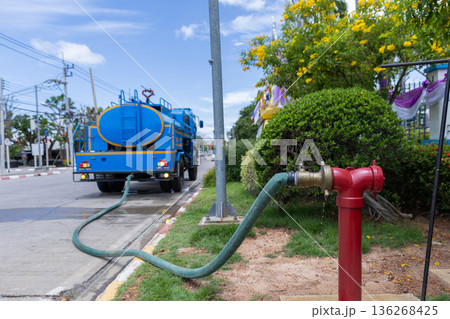 Red hydrant with hose plugs in case of emergency on a sidewalk. 136268425