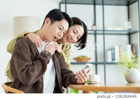 家でスマホを見るミドルの夫婦 家でスマホを見るミドルの夫婦 136268449