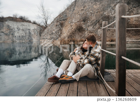 Couple enjoys time by the water on Valentines Day while embracing and sharing love in a serene setting 136268609