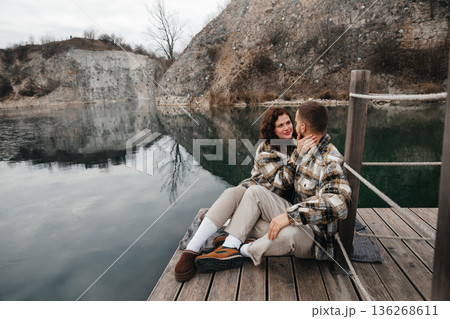 Couple shares a moment on a wooden dock by the water during Valentines Day celebration in winter season 136268611