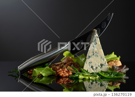 Blue cheese with knife, walnuts and fresh greens. Blue cheese with knife, walnuts and fresh greens. 136270119
