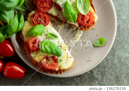 Hot open sandwiches with mozzarella, tomatoes and basil. 136270130
