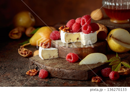 Camembert cheese with pears, fresh raspberries and walnuts. 136270133