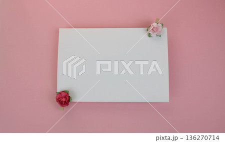 A sheet of white paper for notes with wooden clothespins with red and pink flowers on a pink background. Space for your text. Concept of a holiday, birthday, March 8, Valentine's Day. 136270714