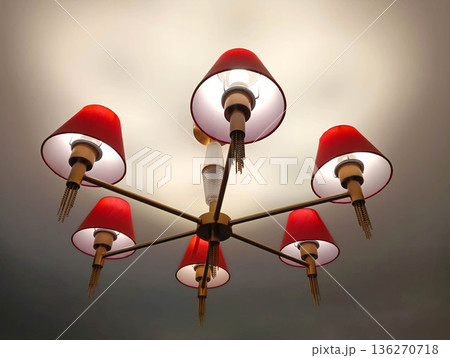 A chandelier with red shades glows from the ceiling A chandelier with red shades glows from the ceiling 136270718