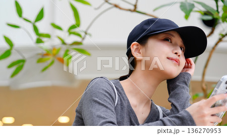 キャップの女性と携帯電話 ■撮影協力：関西国際空港（KIX） 136270953
