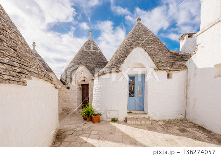 Alberobello, Italy: Historic Trulli houses on a charming street under blue sky Alberobello, Italy: Historic Trulli houses on a charming street under blue sky 136274057