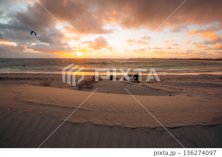Kitesurfer and SUV on a beach at sunset in Australia 136274097