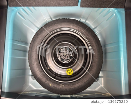 自動車のトランク底面に正対して収納されたスペアタイヤ 136275230