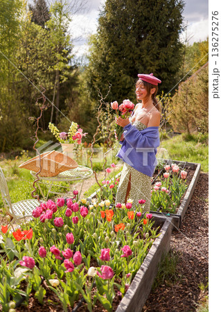 Woman holding tulip bouquet in mountain garden 136275276