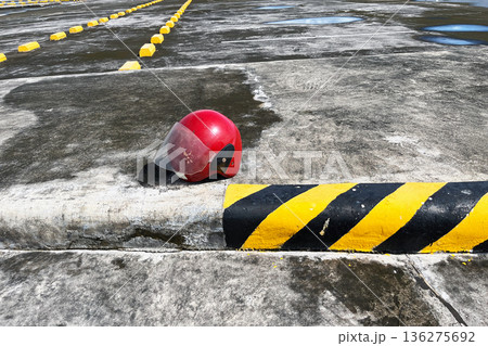 red open face motorcycle helmet with visor on concrete parking lot near yellow and black curb 136275692