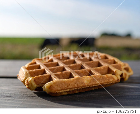 Close up of Freshly Baked Waffle on Rustic Wooden Surface, Farm View Behind. AI Generated. Close up of Freshly Baked Waffle on Rustic Wooden Surface, Farm View Behind. AI Generated. 136275751