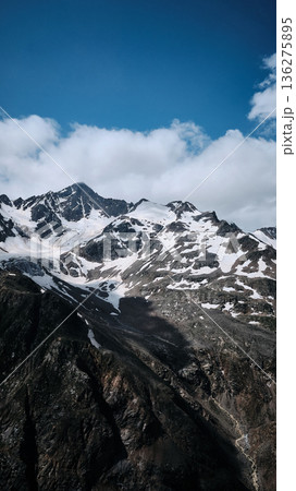 Snow-covered mountain peak under blue sky 136275895